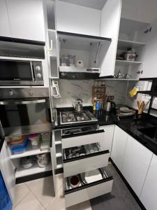 a kitchen with white cabinets and a stove at Appartement Dari proche du centre ville in Agadir