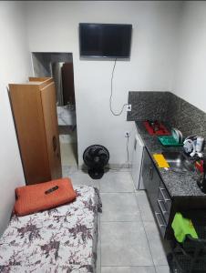 una cucina con un lavandino e un letto in una stanza di choupana mobiliada a Contagem
