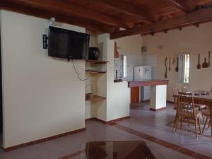 a kitchen and living room with a tv on the wall at Champ Cervi in San Antonio de Arredondo