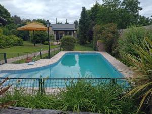 a swimming pool in a yard with an umbrella at Champ Cervi in San Antonio de Arredondo