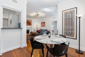 シドニーにあるArt-Deco Gem in Midlothian Opposite Beachのテーブルと椅子のあるダイニングルームとリビングルーム