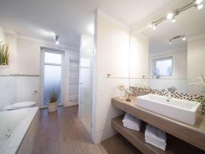 baño con espejo grande, bañera y lavamanos en Holiday home with 1 bedroom, en Rettin 13 fotos más