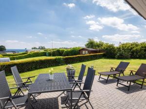 un patio con mesa, sillas y un campo en Holiday home with 1 bedroom, en Rettin