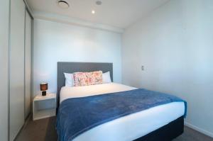 a small bedroom with a bed with a blue and white at Amazing Skytower View 2 Bedroom 2 bathroom Apartment in Auckland +30 photos