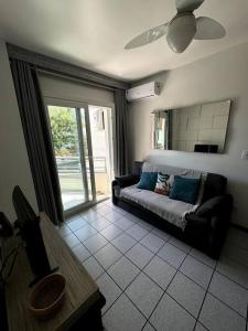a living room with a couch and a table at Ap no centrinho de Canasvieiras ,2 quadras mar in Florianópolis