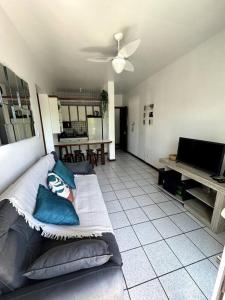 a living room with a couch and a television at Ap no centrinho de Canasvieiras ,2 quadras mar in Florianópolis