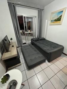 a bedroom with a black bed in a room at Ap no centrinho de Canasvieiras ,2 quadras mar in Florianópolis