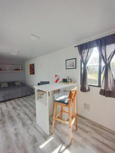 a room with a desk with a chair and a bed at Nuna Tiny House in El Chalten