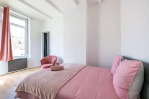 a bedroom with a pink bed and a chair at Les Appart'Hôtels Du Calaisis - Pinky Terrasse 103 in Calais