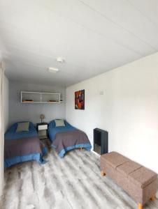 a bedroom with two beds and a couch at Nuna Tiny House in El Chalten