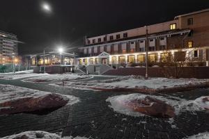 a courtyard covered in snow in front of a building at Sibirskiy Safari Club in Krasnoyarsk