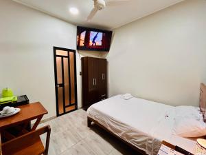 イキトスにあるHabitación Céntrica en Iquitos - Casa Alemi 8のベッドと壁にテレビが掛かった寝室