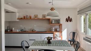 a kitchen with a table and chairs in a room at Aiila House in Esquel