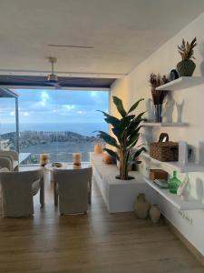 a living room with a table and a large window at Villa Olimonte in Valverde