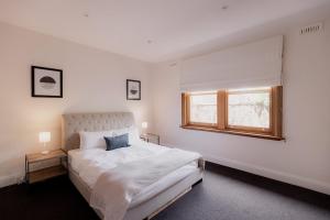 Una habitación blanca con una cama y una ventana en Modern Home in Sandy Bay - Sleeps 8 Guests, en Sandy Bay
