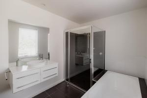 Un baño blanco con lavabo y ducha en Modern Home in Sandy Bay - Sleeps 8 Guests, en Sandy Bay 29 fotos más