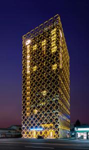 a building with a lit up facade at night at Hotel The Designers Dongdaemun in Seoul