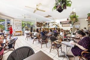 a group of people sitting at tables in a restaurant at 'Tres Botanica' Nightcliff Escape for Groups, Three Adjacent Apartments in Nightcliff