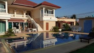 a house with a swimming pool in front of a house at East Shore Pattaya Resort in Nong Prue