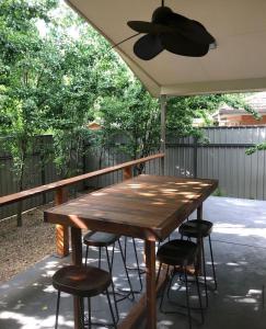 a wooden table and chairs on a porch with a ceiling fan at Bright Delight in Bright