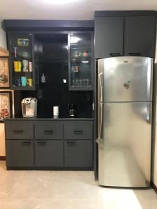 a kitchen with a stainless steel refrigerator and cabinets at Descanso y diversión a 10 min puet. Anzalduas in Reynosa