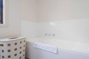 SeafordSeaford Escape - Simple Comforts, Perfect Location的带浴缸和水槽的白色浴室 更多18张照片