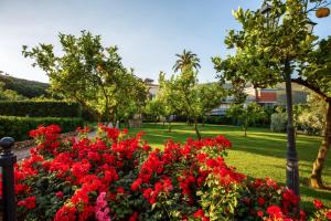 a garden with red flowers in a park at Villa Irlanda Grand Hotel in Gaeta