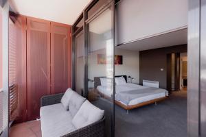 a bedroom with two beds and a glass wall at Inner-city 2 bedroom apartment - perfectly located in Hobart