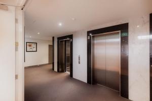 an empty hallway with two elevators in a building at Inner-city 2 bedroom apartment - perfectly located in Hobart