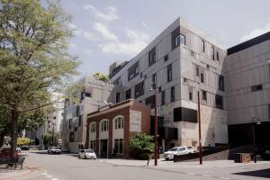 a building on a street with cars parked in front of it at Inner-city 2 bedroom apartment - perfectly located in Hobart