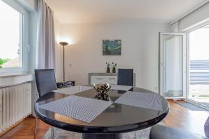 une salle à manger avec une table et des chaises noires dans l'établissement Silvaner-Laube Ferienwohnung Silvanerlaube A, à Meersburg