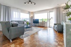 un salon avec un canapé, des chaises et une télévision dans l'établissement Silvaner-Laube Ferienwohnung Silvanerlaube A, à Meersburg