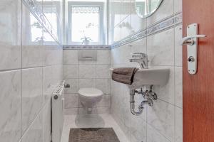 une salle de bain blanche avec un lavabo et des toilettes dans l'établissement Silvaner-Laube Ferienwohnung Silvanerlaube A, à Meersburg 32 autres photos