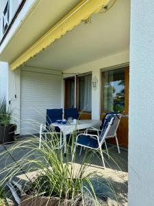 a patio with a table and chairs on a house at StrandGut in Uhldingen-Mühlhofen