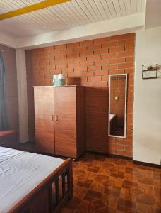 a room with a brick wall with a bed and a mirror at Habitacion La Candelaria en Riosucio in Ruiosucio +1 photo