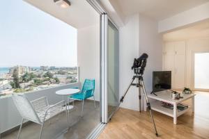 eine Kamera und Stühle in einem Zimmer mit Fenster in der Unterkunft Limanaki Beach Aparment in Larnaka