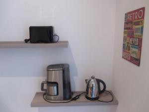 une cafetière et une cafetière sur une étagère dans l'établissement Nice Studio Old Town Sea Side, à Nice
