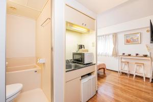 een kleine badkamer met een wastafel en een magnetron bij 新宿区歌舞伎町伊势丹徒步3分钟#6 in Tokyo