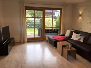 a living room with a couch and a tv at Boutiqueferienwohnung Schnapshäusel in Oberstdorf