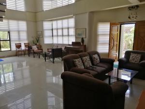a large living room with chairs and a piano at JD Homestays CDO in Cagayan de Oro