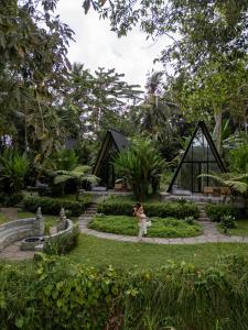 a woman taking a picture of a garden at Delta Casa Ubud - A-Frame Jungle Retreat with Volcano View and Hot-Tubs in Gianyar