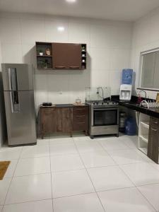 a kitchen with a stainless steel refrigerator and cabinets at Casa Miguel Arcanjo in Cascavel