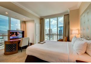 a hotel room with a bed and a flat screen tv at MGM Signature Top Floor 1 BR 2 BA Penthouse with Balcony, Strip and Sphere Views in Las Vegas +22 photos