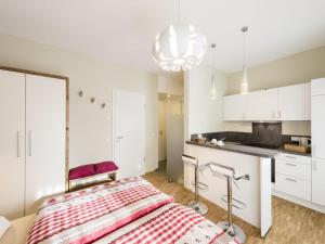 ein Schlafzimmer mit einem Bett und eine Küche mit weißen Schränken in der Unterkunft Webers "alte Backstube" in Friedrichshafen