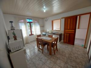 a kitchen with a table and chairs and a refrigerator at Cantinho do silêncio in Joinville