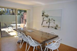 a dining room with a wooden table and chairs at Baybreeze - Bring your own linen in South West Rocks