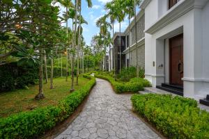 einen Gang vor einem Gebäude mit Bäumen in der Unterkunft Maikhao Dream Villa Resort and Spa, Maikhao Phuket in Mai Khao Beach