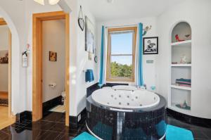 een badkamer met een bad in het midden van de kamer bij The Starlight Tower Hot Tub Suite with 8-Jet Massage Shower and Amazing Views in Fort Atkinson