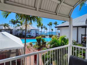 a balcony with a view of a swimming pool at Serenity in Eimeo
