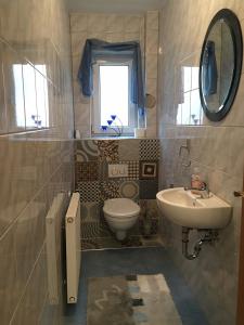 ein Bad mit einem Waschbecken, einem WC und einem Fenster in der Unterkunft Apartment Gosberg - 90qm in Pinzberg